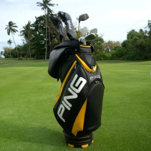A golf bag filled with clubs rests on a vibrant green field, highlighting a perfect day for golfing